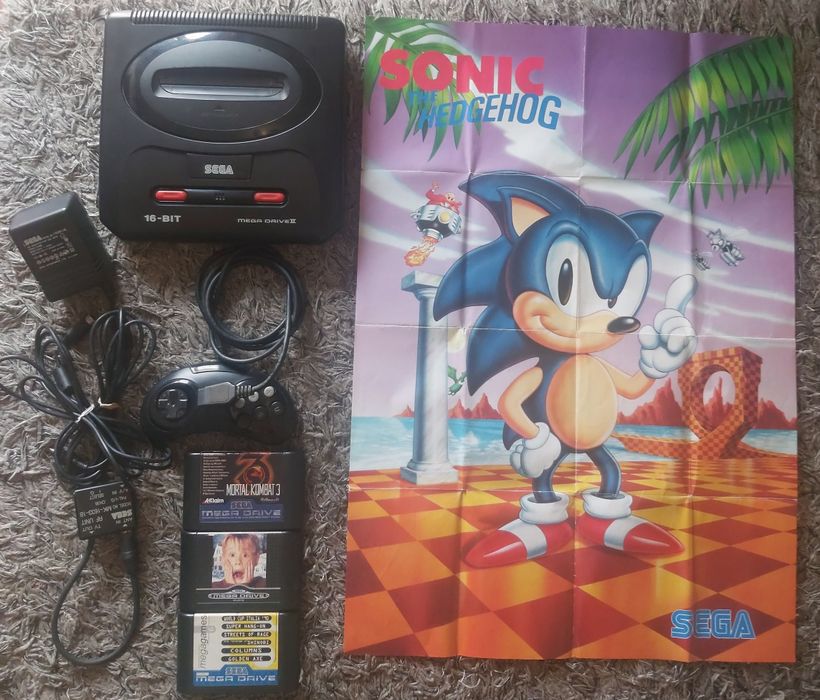 Mega drive ll com jogos e pôster sega.