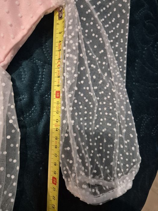 Piękna sukienka bladoróżowa z przezroczystymi rękawami i kokardą