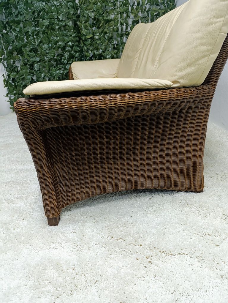 Piekna sofa rattanowa z poduchami ze skóry naturalnej.