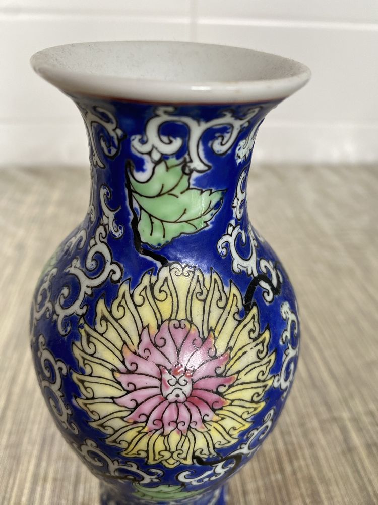 Vaso antigo pequeno com flores entrelaçadas