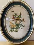 Quadro oval vintage com bordado em linho e moldura verde e dourada