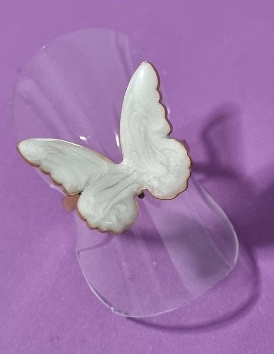 Anel dourado, em açol, com borboleta branca esmaltada. Ajustável
