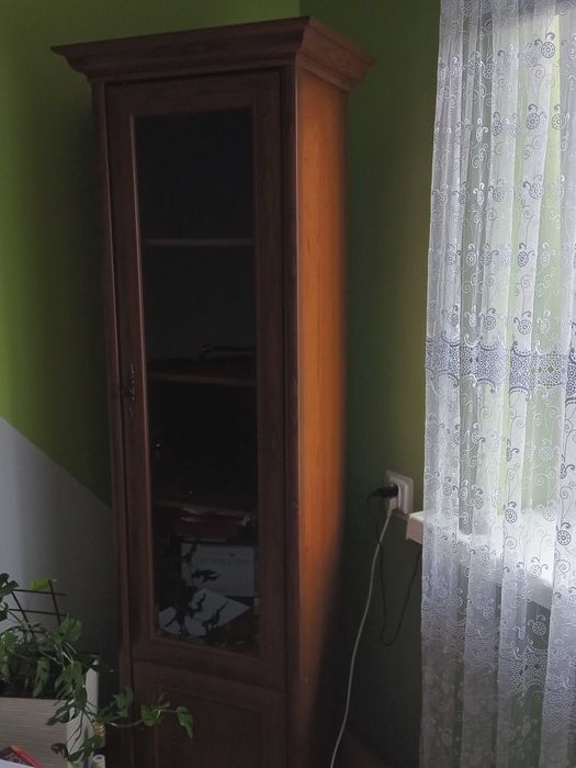 Zestaw mebli szafka RTV i słupek przeszklony.