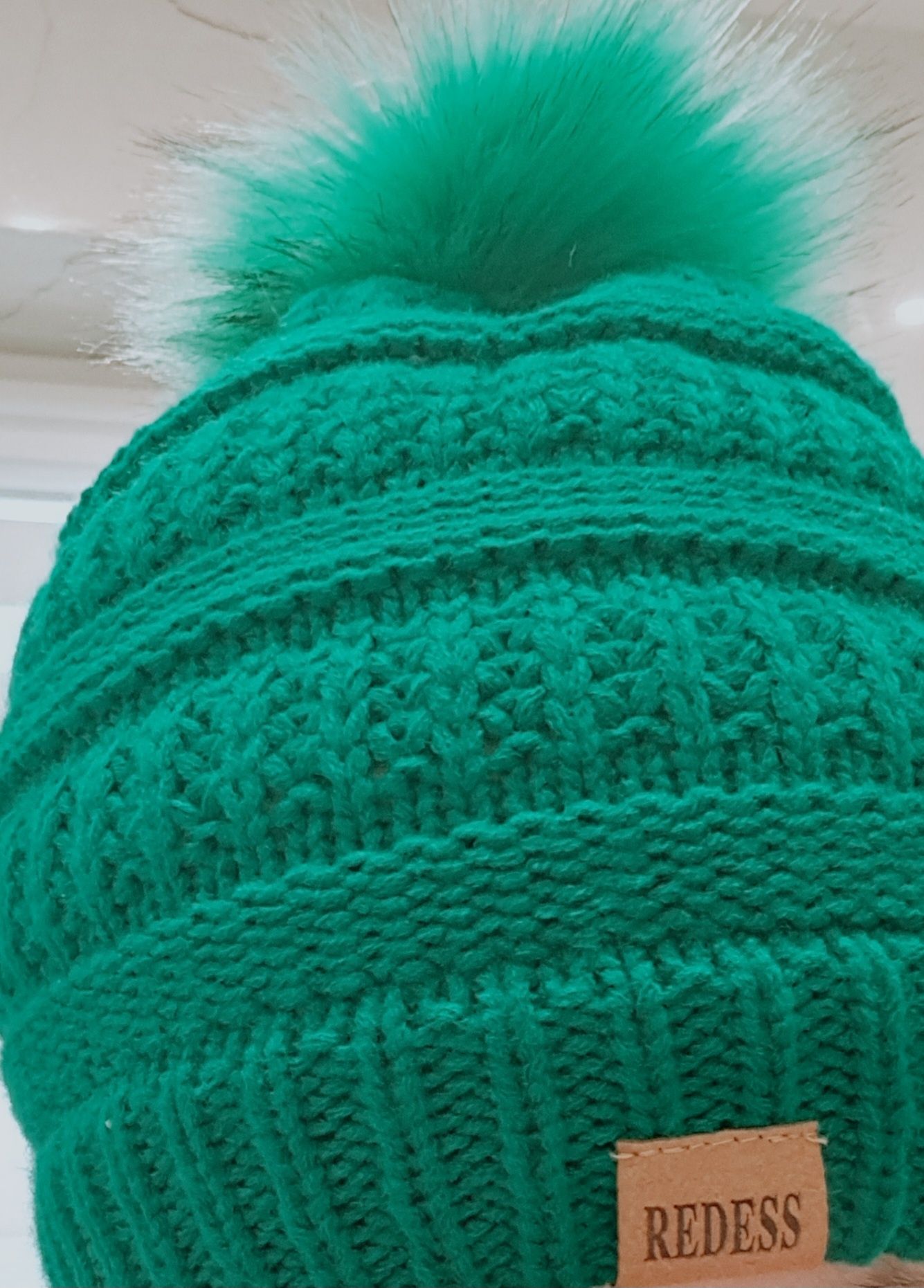 Zielona ocieplana czapka z puszystym pomponem