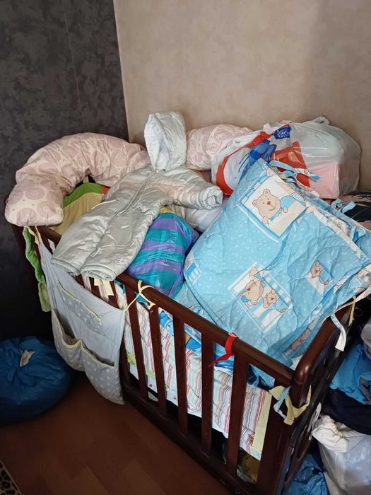 Дитяча кроватка у стані нової з постіллю та іншими речами в подарунок
