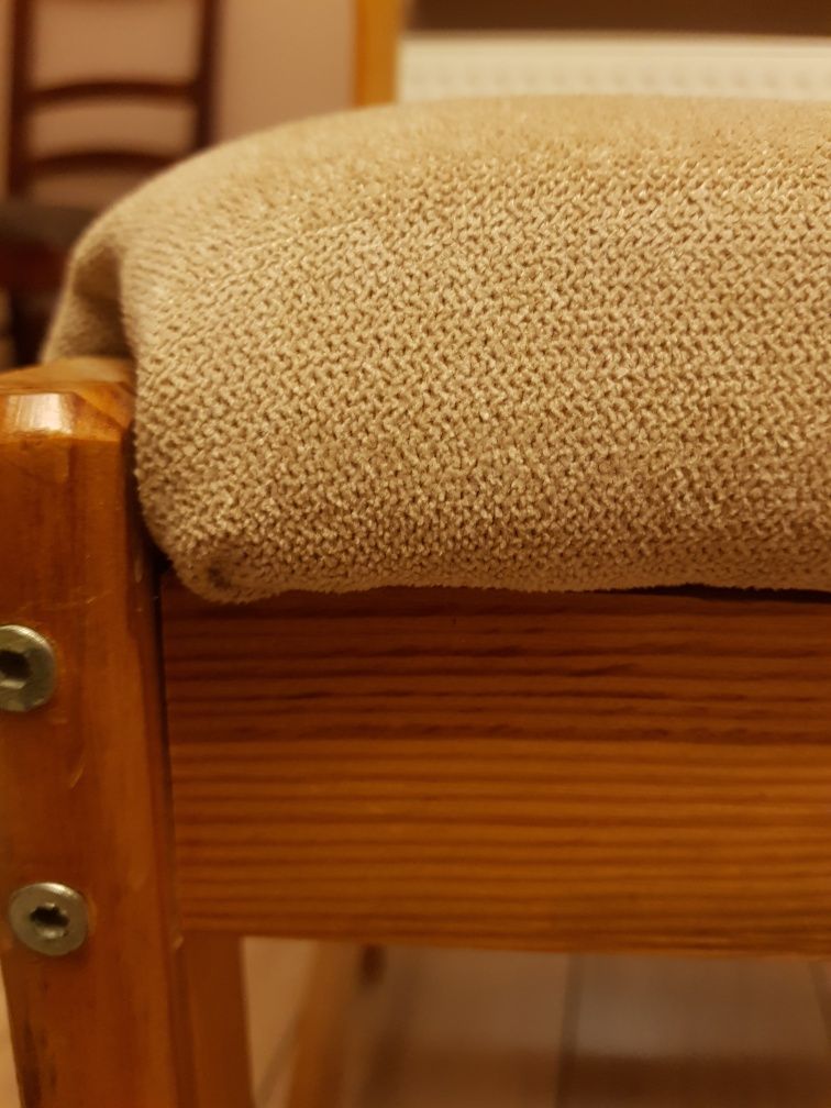 Krzesło sosnowe z miękkim siedziskiem w kolorze beżu.