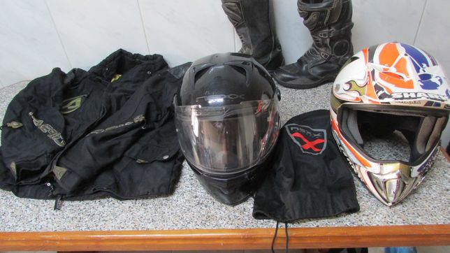 Dois capacetes, botas e casaco de mota