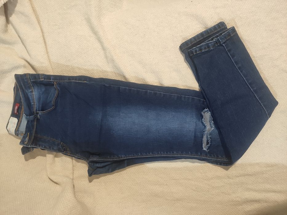 granatowe jeansy z dziurami na kolanach