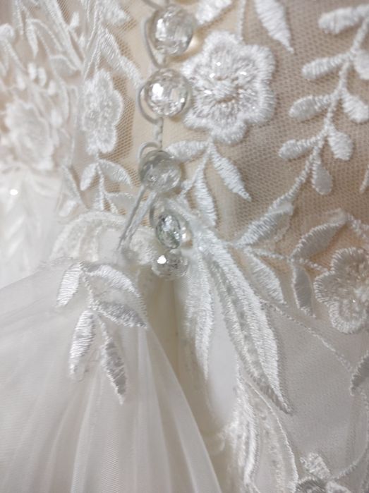 Piękna suknia ślubna z podpinany trenem