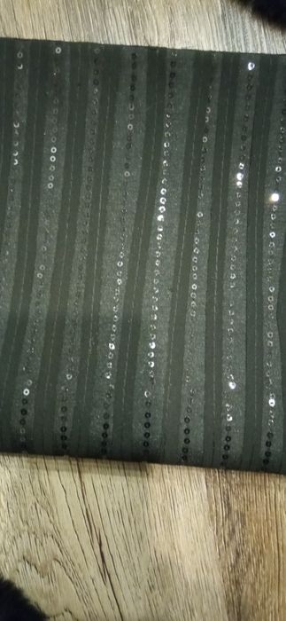 Czarny bieżnik pokryty czarnymi cekinami.