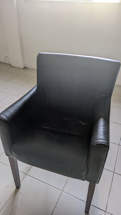 Cadeirão estofado em pele sintética preta.
Ca
