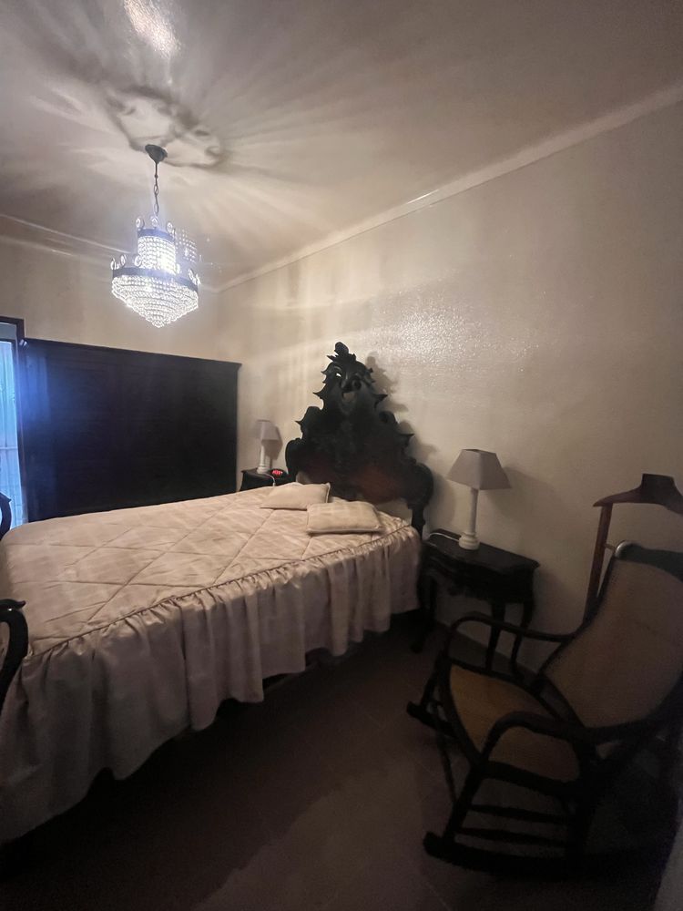 Quarto com cama, roupeiro, mesas de cabeceira e comoda