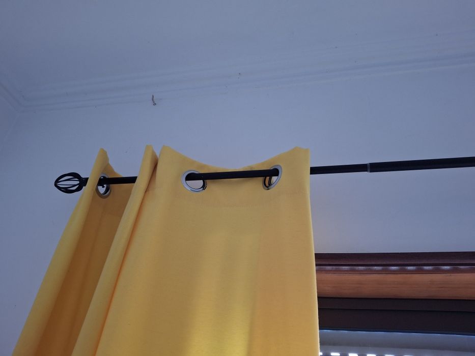 Varão e cortinados amarelos