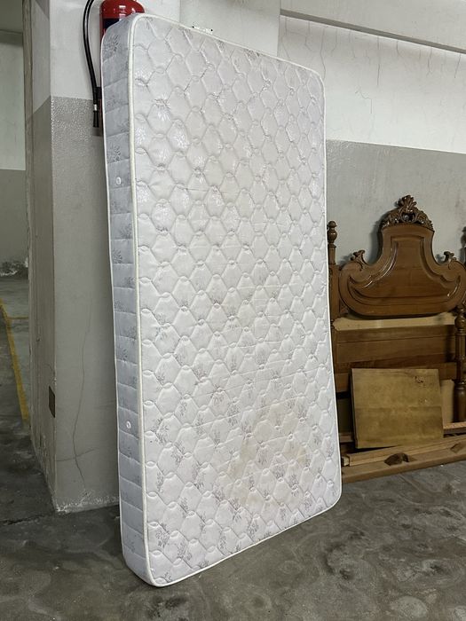 Cama de madeira, colchão e mesinha de cabeceira