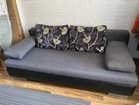 Szara sofa z funkcją spania 150x200 cm ze schowkiem na pościel