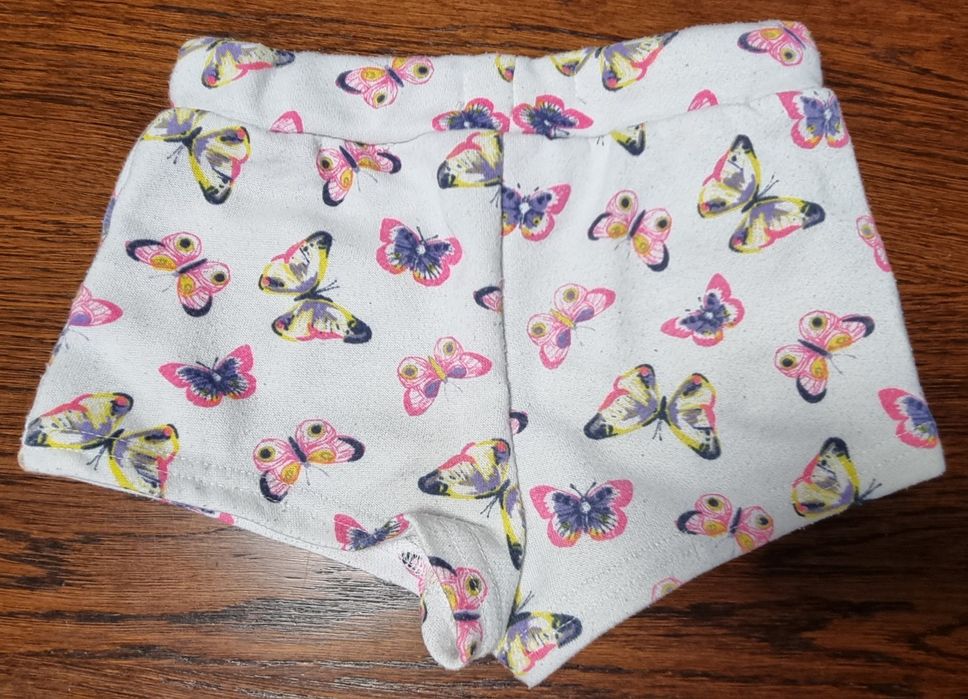 Kremowe krótkie spodenki w motylki. Sinsay 104cm.
