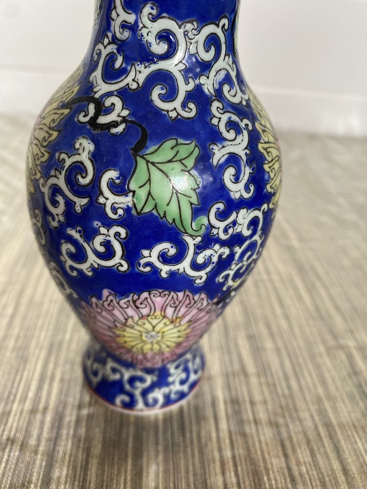 Vaso antigo pequeno com flores entrelaçadas