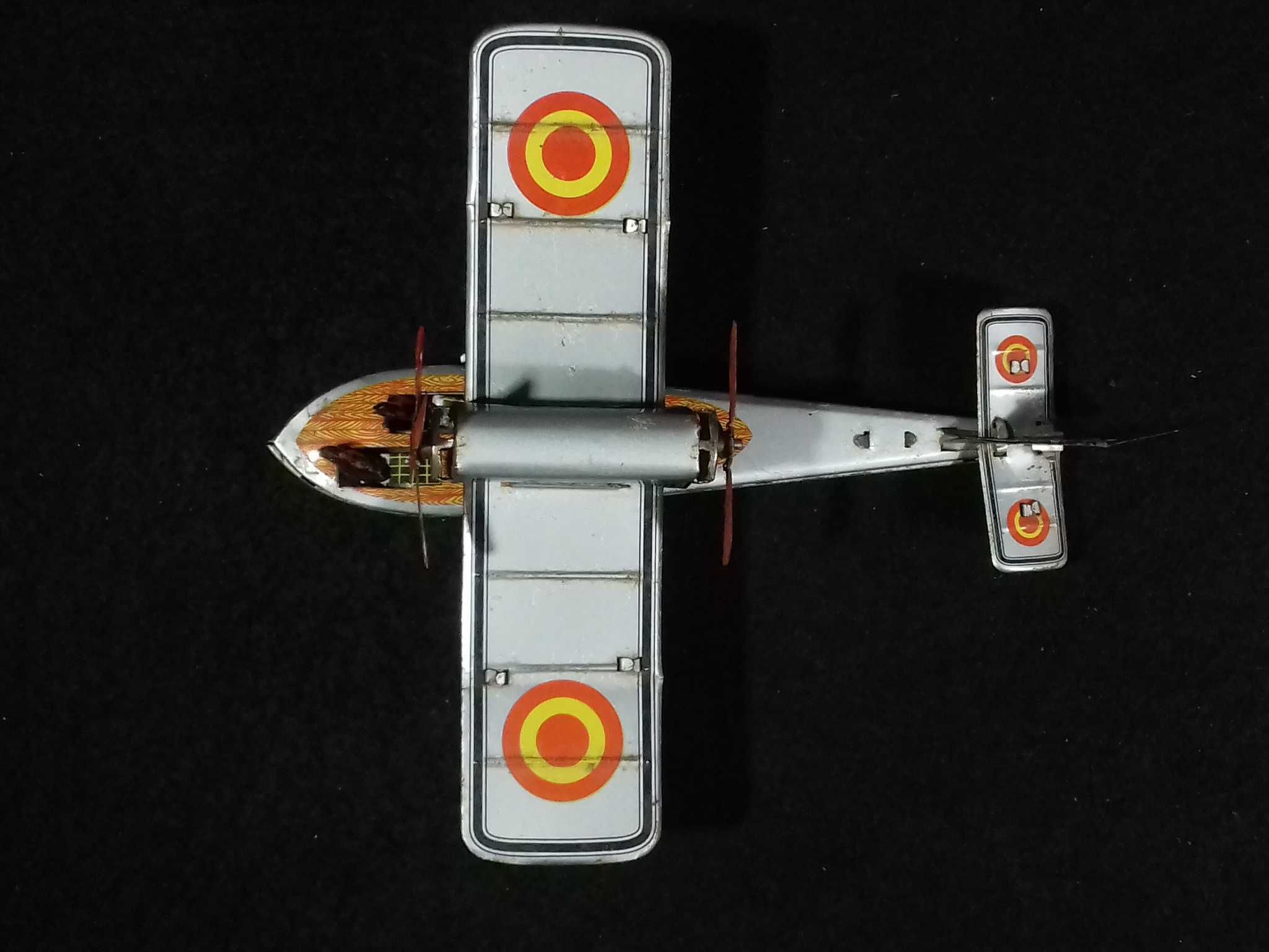 Miniatura de avião antigo em metal, com sistema mecânico de corda;
