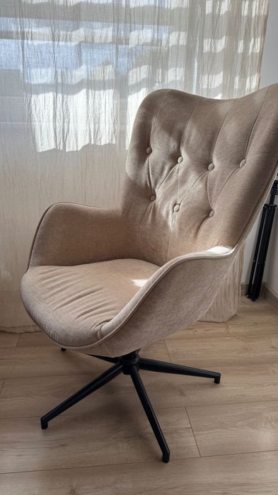 Welurowy fotel do salonu obrotowy beżowy podstawa czarna