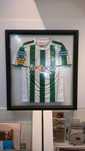 Camisa Vitória perfeitamente emoldurada entre dois vidros