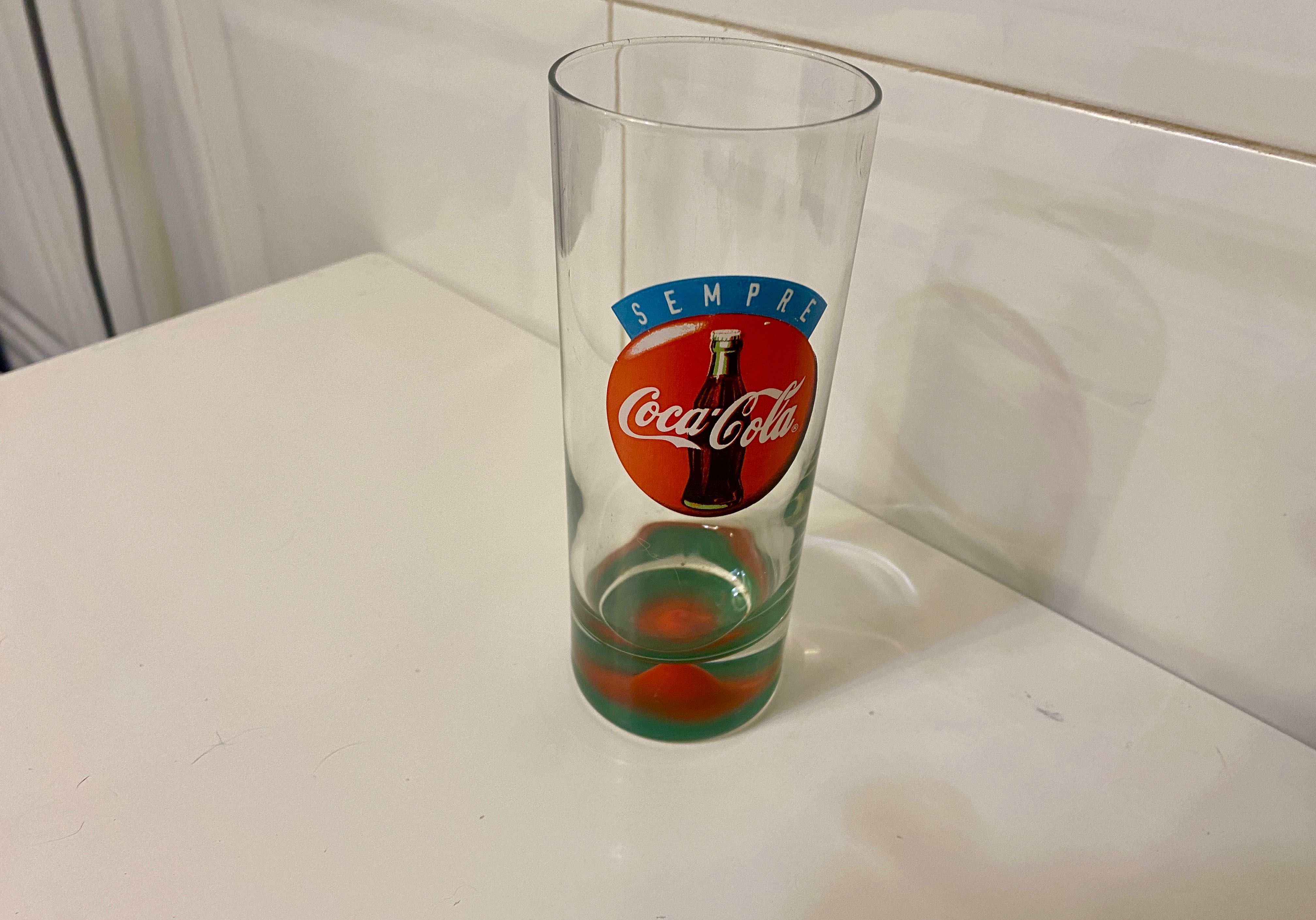 Copo antigo coca cola com relevo mama no fundo.