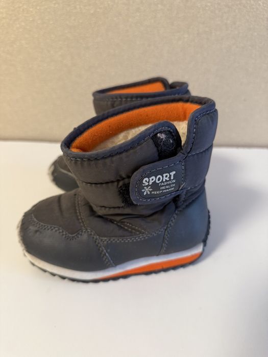 Дитячі зимові сапожки біля дому