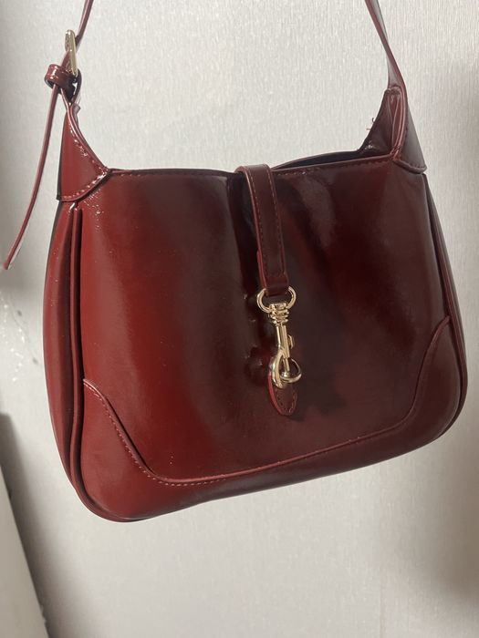 Сумка бордового кольору.