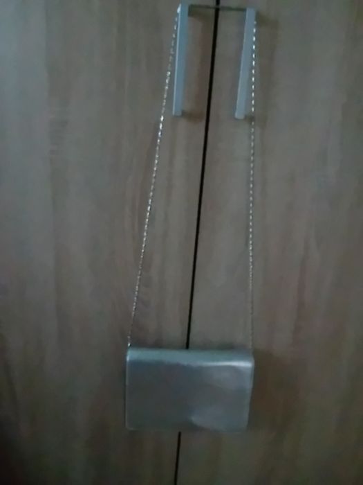 Torebka damska koloru srebrnego z z dłuszym paskiem srebrnym.