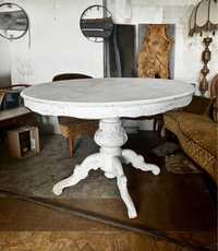 Stary piękny duży okrągły stół na rzeźbionej nodze