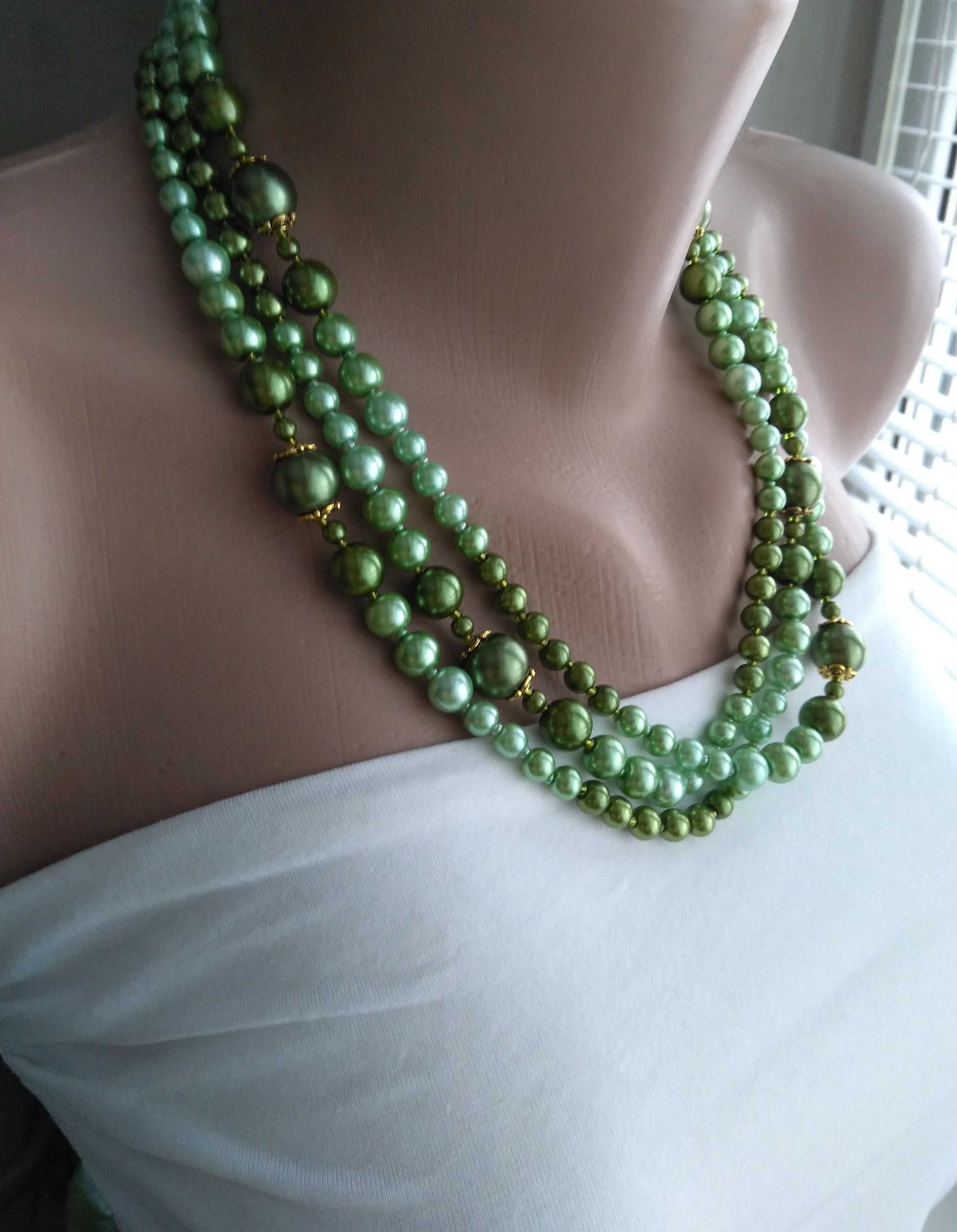 Довге намисто зі скляних перлів зелених відтінків.