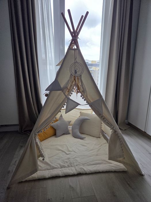 Tipi z matą poduszkami i girlandą