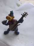 Figura de dinossauro guitarrista