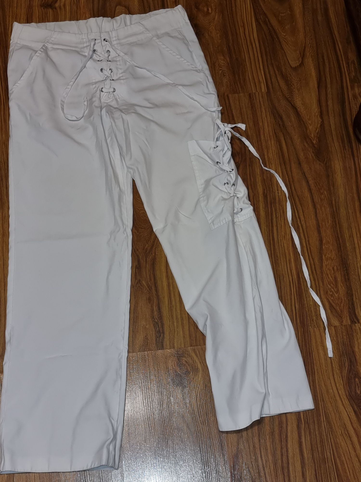 Białe bojówki z kieszenią na nogawce