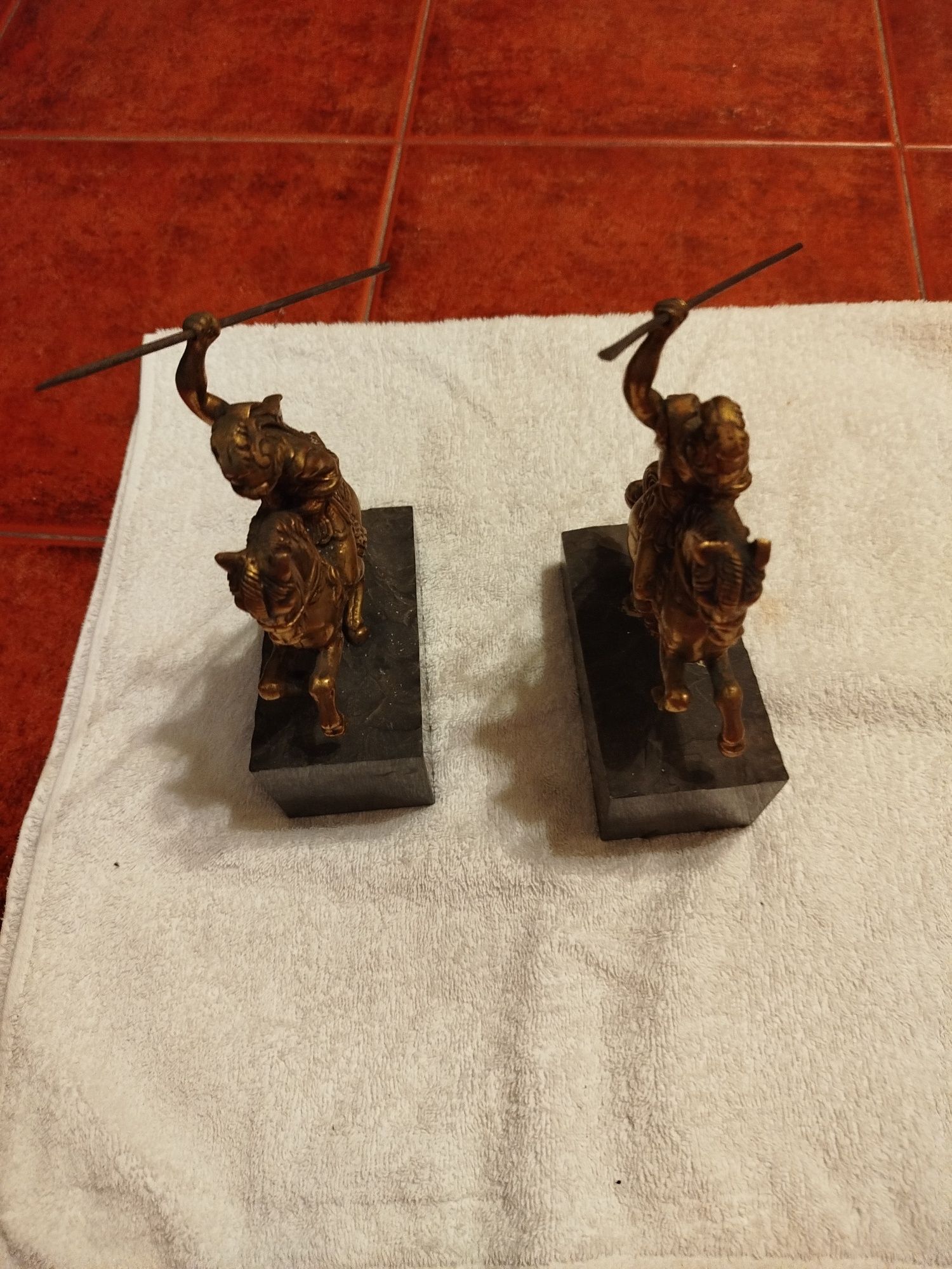 Duas esculturas antigas de um guerreiro em bronze e bases de mármore