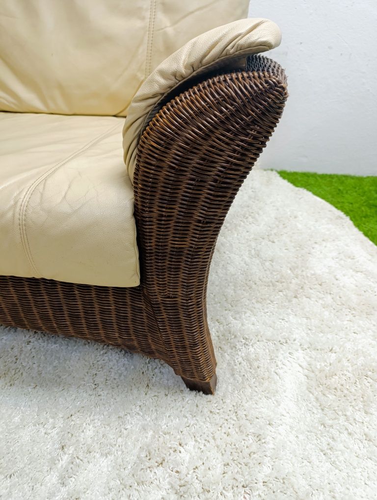 Piekna sofa rattanowa z poduchami ze skóry naturalnej.