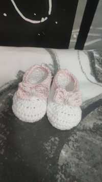 Białe własnoręcznie robione buciki niemowlęce