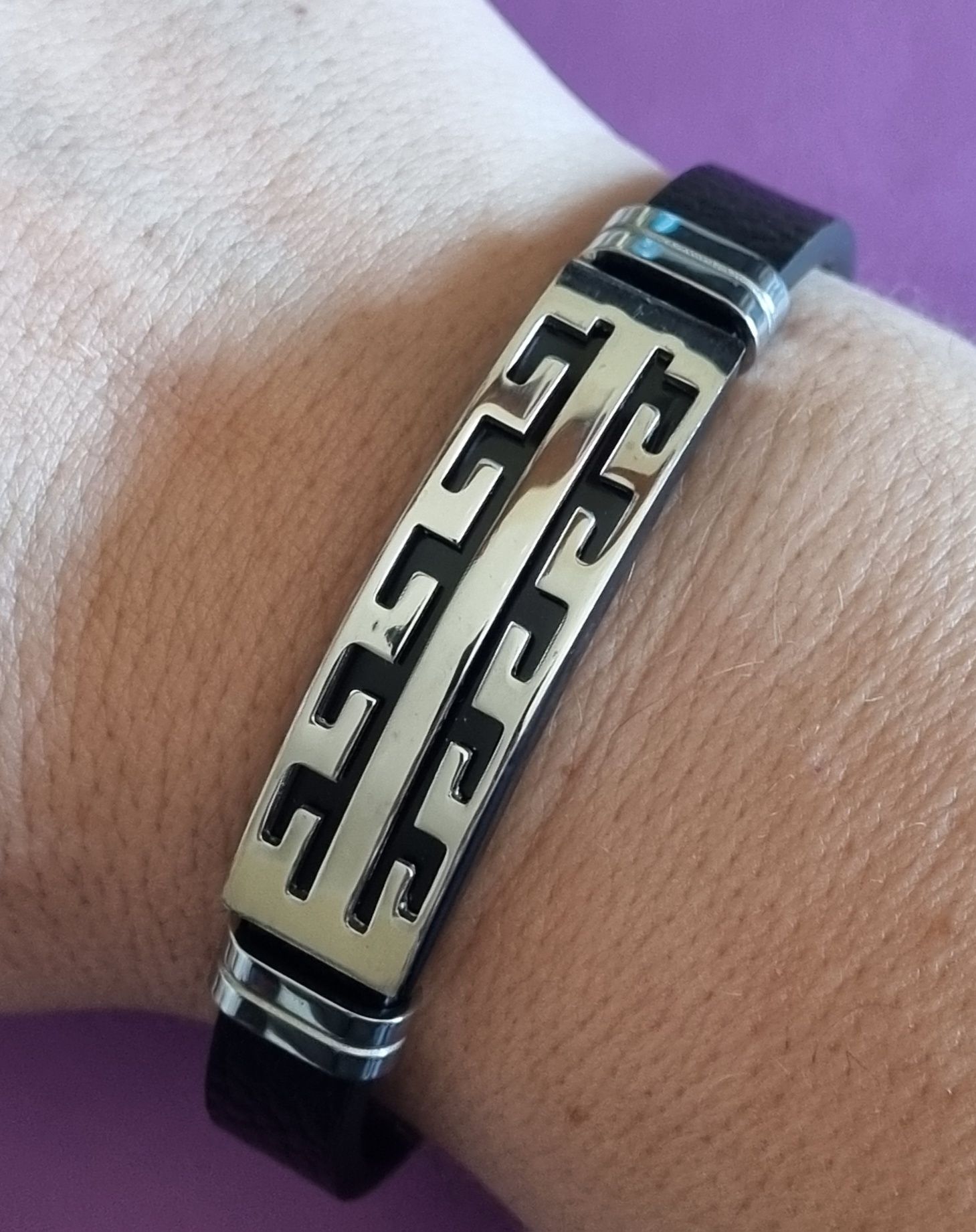 Pulseira de cabedal preto com peças prateadas em aço inoxidável.