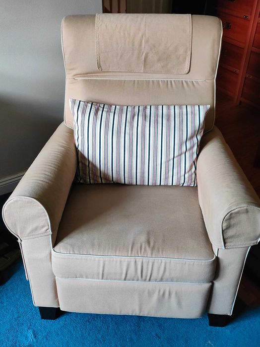 Beżowy fotel rozkładany.