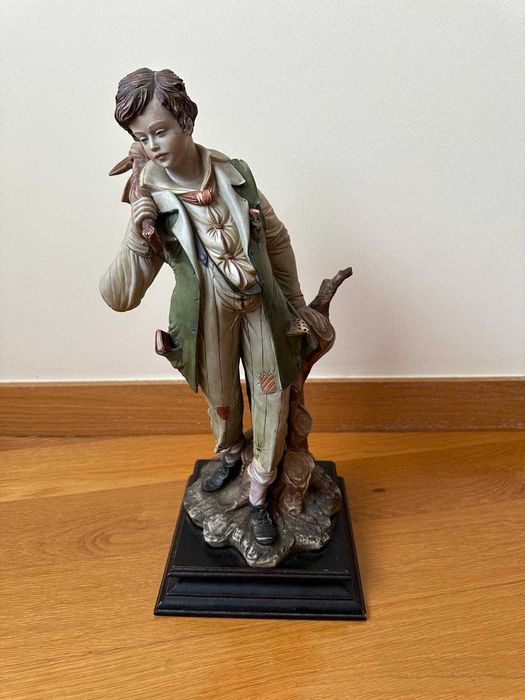 Estatueta de menino com saco ao ombro