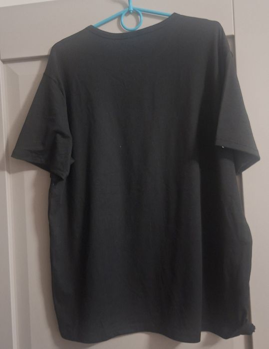 Czarna koszulka świąteczna z nadrukiem Mikołaja i napisem „HO HO HO”.