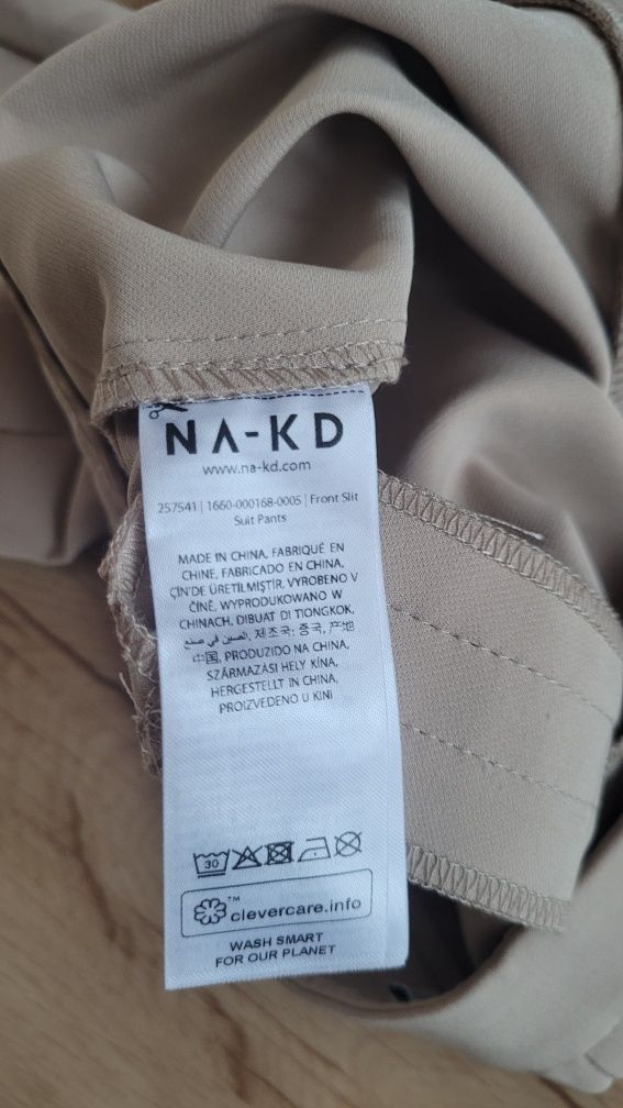 Beżowe spodnie flare z rozcięciem NA-KD XS 34