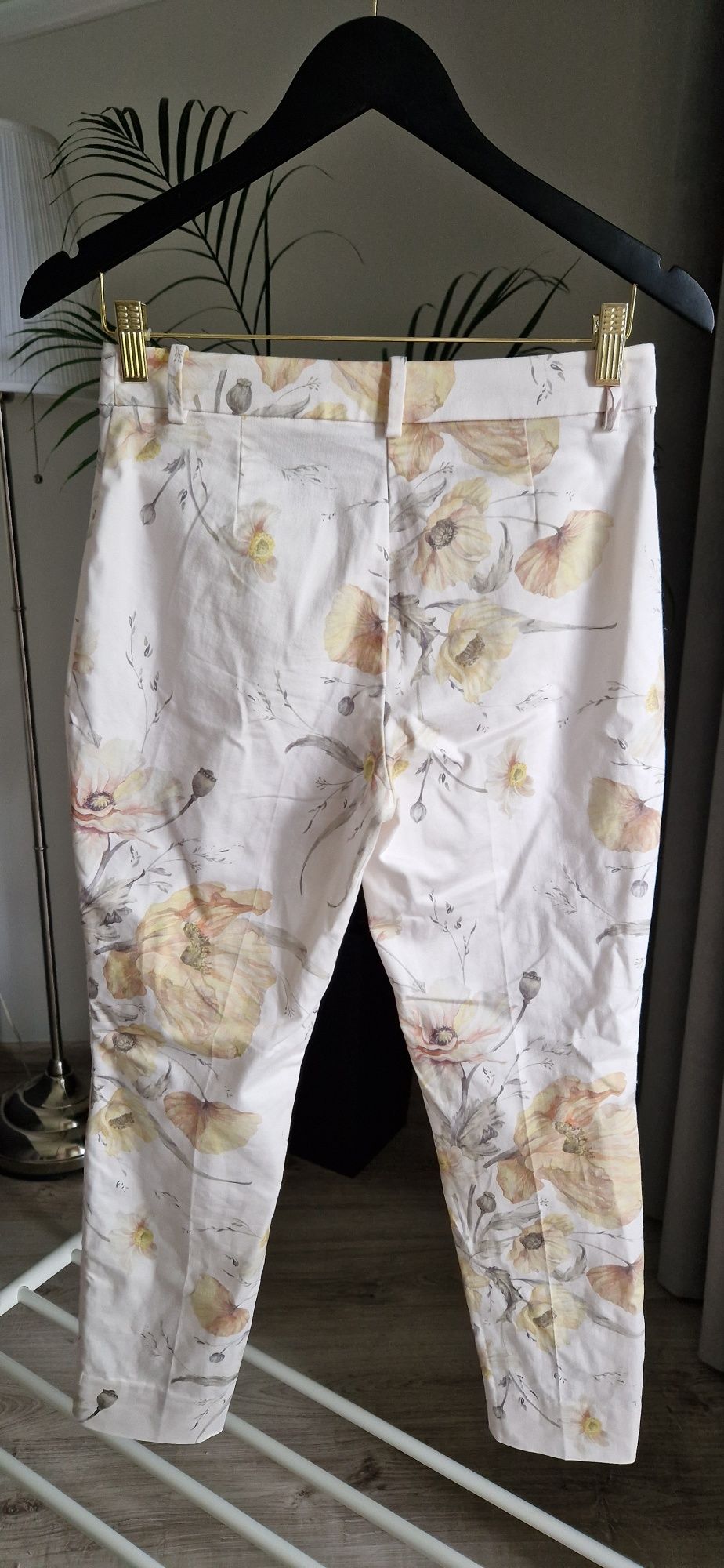 Białe spodnie damskie w kolorowe kwiaty H&M rozmiar M