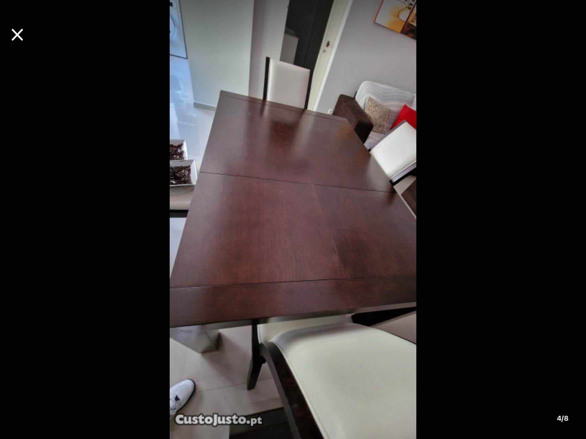 Conjunto de móveis de sala com mesa e cadeiras de pele.