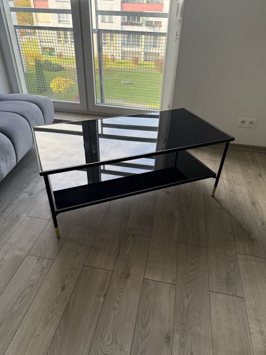 Czarna szklana ława ze złotymi dodatkami