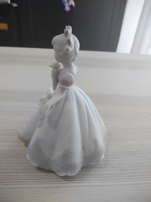 A estatueta de porcelana.