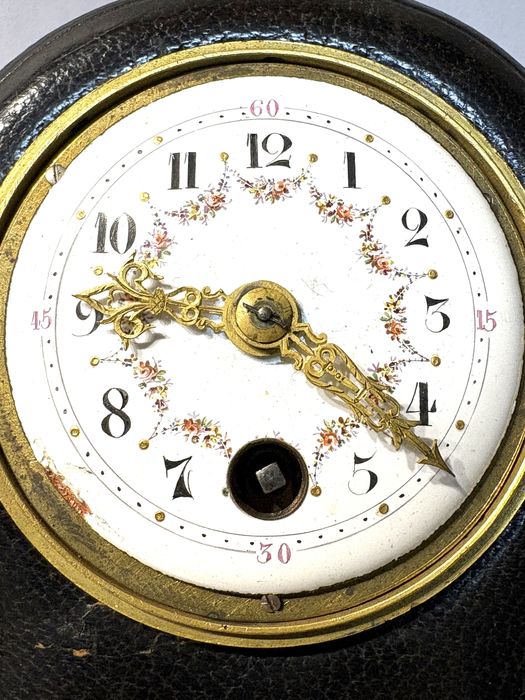 Antigo relógio de viagem com mostrador esmaltado e caixa em couro