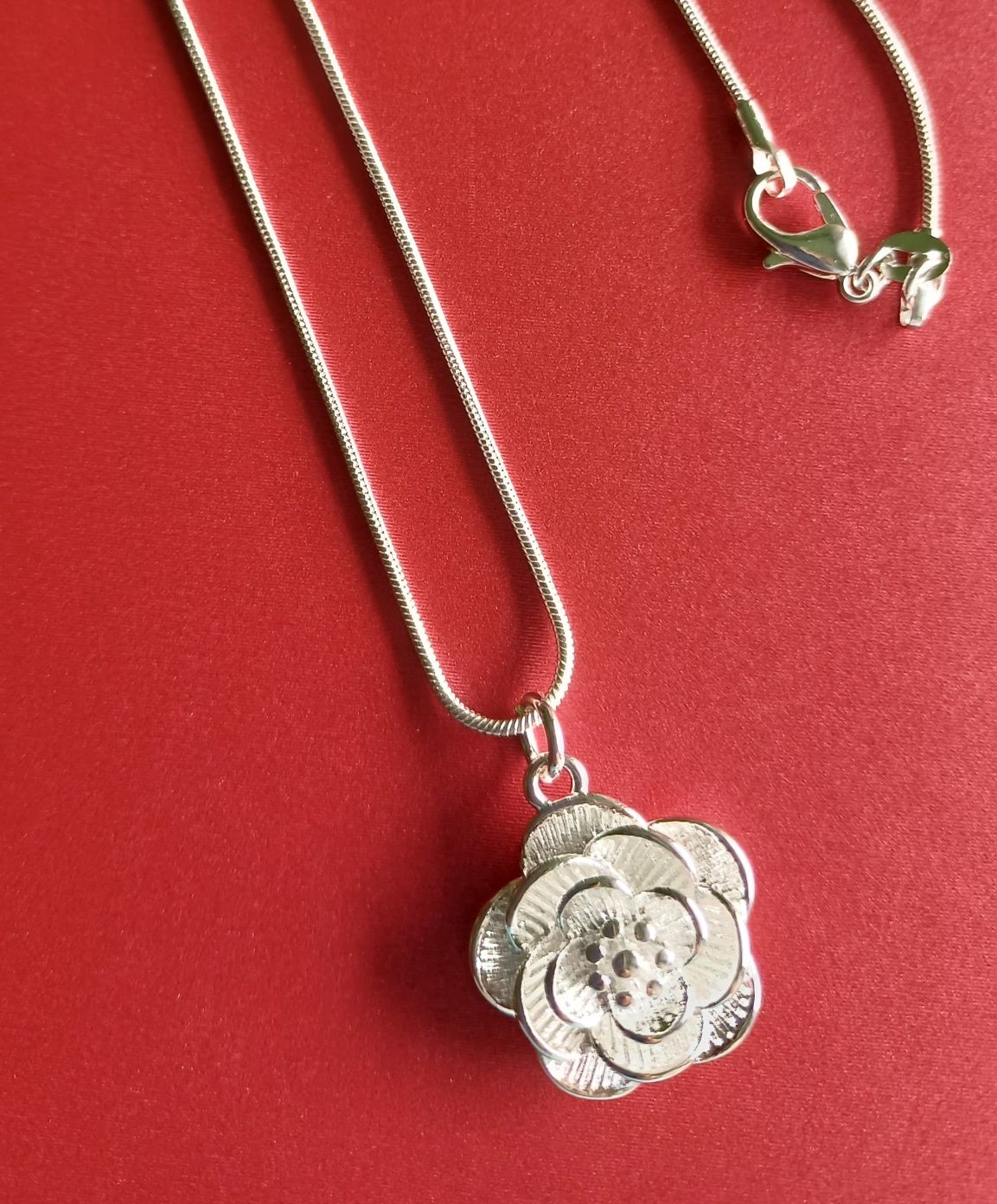 Srebrny naszyjnik z kwiatem róży.