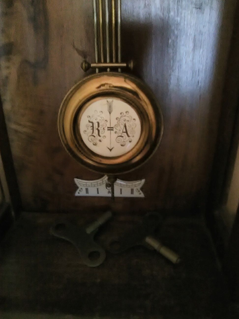 Zegar scienny z wahadlem z emaliowana tarcza.