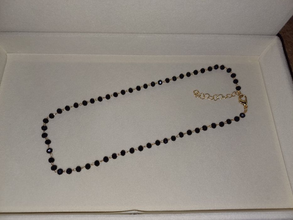 Colar dourado com contas pretas. Novo.