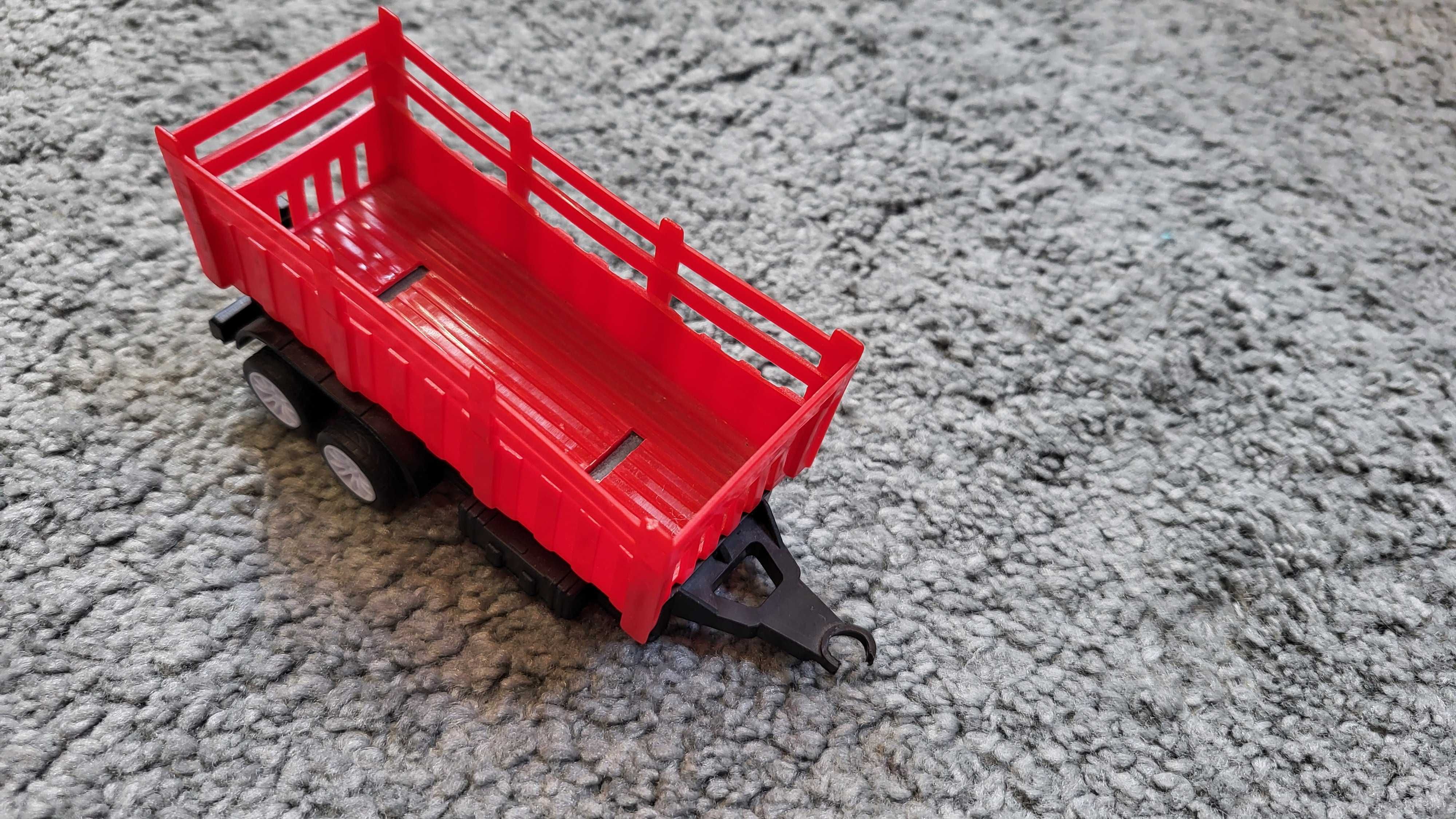 Czerwony traktor z przyczepą